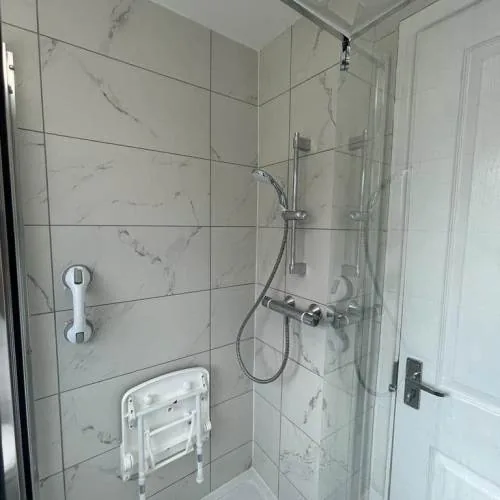 Accessible shower with fold-down seat and grab rail