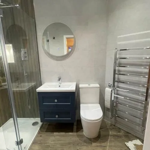 Bathroom with navy vanity unit and chrome towel rail