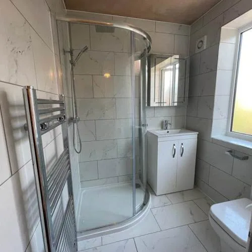 En-suite with quadrant shower enclosure and chrome heated towel rail