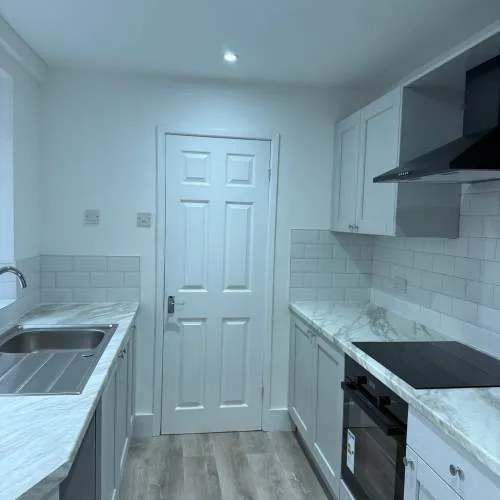 Grey shaker kitchen with marble-effect worktops and built-in oven