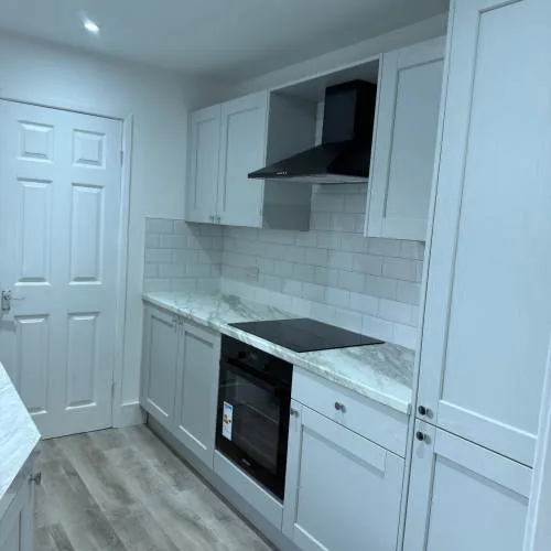 Shaker-style kitchen with black extractor hood and built-in oven