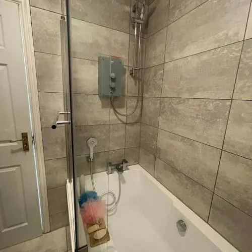 Shower bath with grey large-format wall tiles