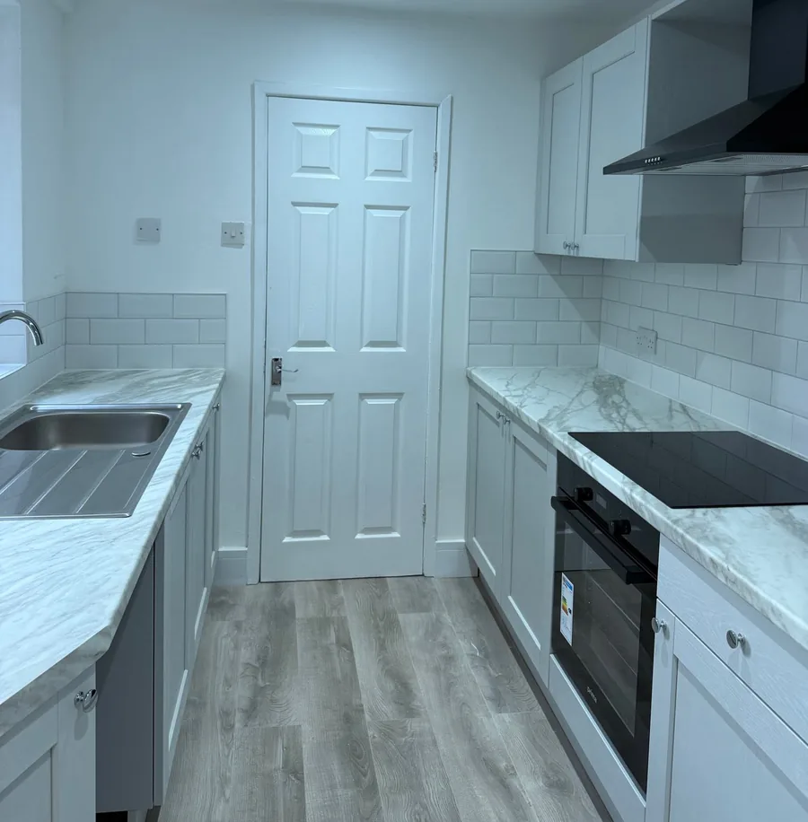 Grey shaker kitchen with marble-effect worktops and built-in oven in Warrington
